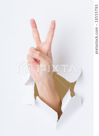 Woman hand breaking through paper wall pointing with the two fin Woman hand breaking through paper wall pointing with the two fin 18555793