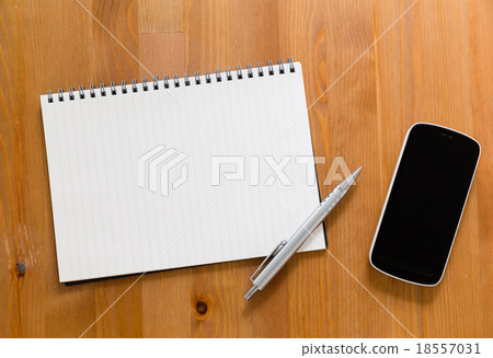 Mobile phone on desk with blank handbook for input something 18557031