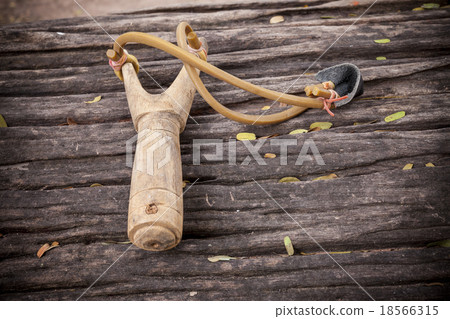 Slingshot on old wood table. Slingshot on old wood table. 18566315