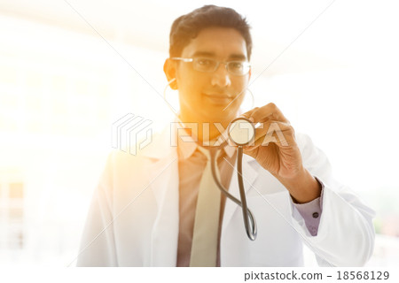 Asian Indian medical doctor holding stethoscope Asian Indian medical doctor holding stethoscope 18568129