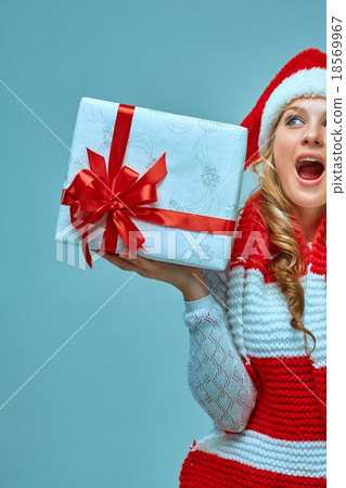 Girl dressed in santa hat with a Christmas gift  18569967
