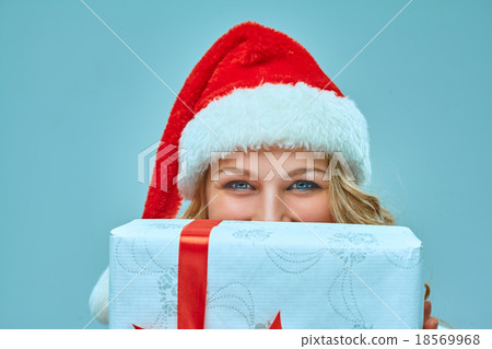 Girl dressed in santa hat with a Christmas gift  18569968
