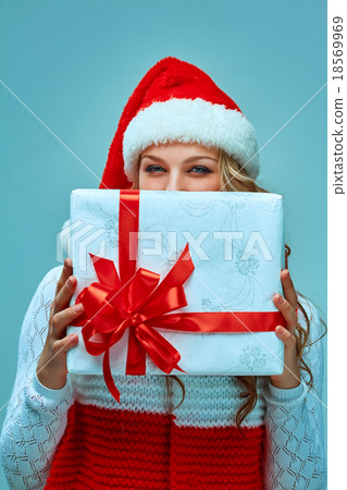 Girl dressed in santa hat with a Christmas gift  18569969