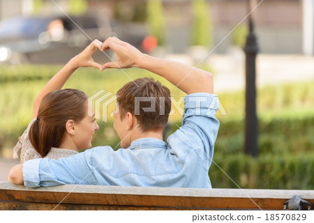 Nice young couple sitting on the bench  18570829