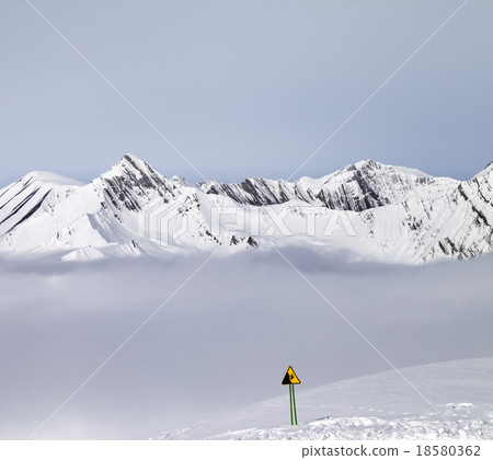 Mountains in mist and warning sing on ski slope 18580362