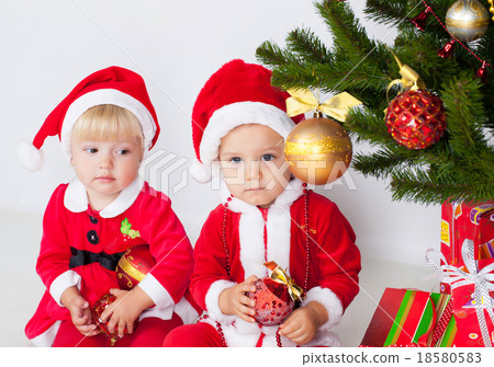 Two children under christmas pine 18580583