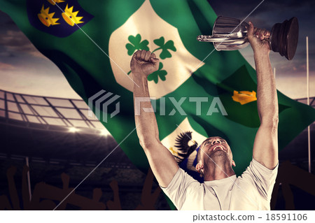 Composite image of happy rugby player holding trophy 18591106
