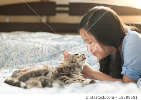 Beautiful asian girl kissing american shorthair cat 18599581