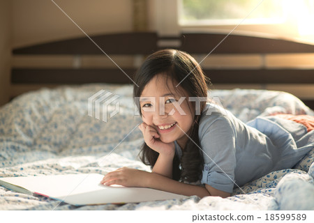 Happy asian girl reading 18599589