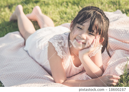 Beautiful asian girl lying on green gras Beautiful asian girl lying on green gras 18600287