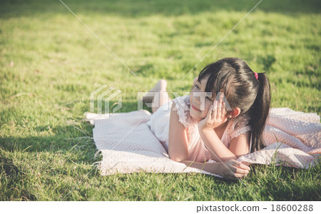 Beautiful asian girl lying on green gras 18600288