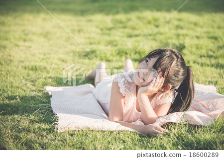 Beautiful asian girl lying and looking up on green grass Beautiful asian girl lying and looking up on green grass 18600289