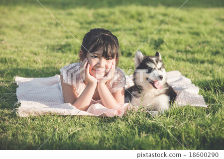 Beautiful asian girl lying on green grass with a siberian husky Beautiful asian girl lying on green grass with a siberian husky 18600290