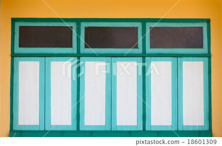 Green white window on yellow wall 18601309