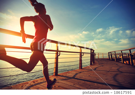 young fitness woman running at sunrise beach 18617591