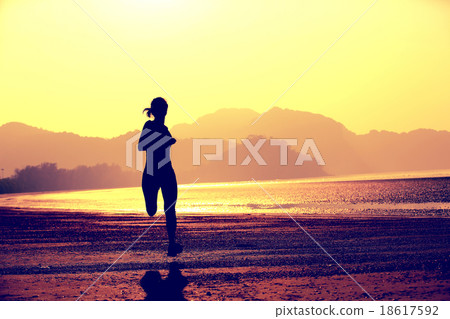 young fitness woman running at sunrise beach 18617592