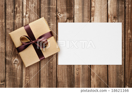 Gift box and greeting card on wooden background Gift box and greeting card on wooden background 18621166