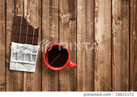 Chocolate bar and coffee cup on wooden table Chocolate bar and coffee cup on wooden table 18621172