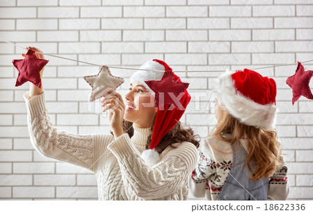 mother and daughter hang a garland mother and daughter hang a garland 18622336