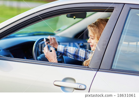 young woman driving a car and using phone young woman driving a car and using phone 18631061
