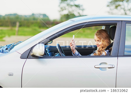 young woman driving a car and using phone young woman driving a car and using phone 18631062