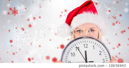 Composite image of festive blonde holding a clock 18636943