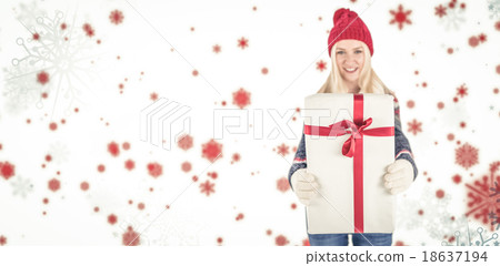 Composite image of festive blonde holding a gift 18637194