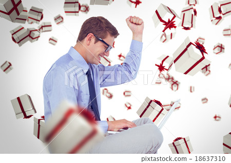 Composite image of businessman wearing glasses and using laptop 18637310