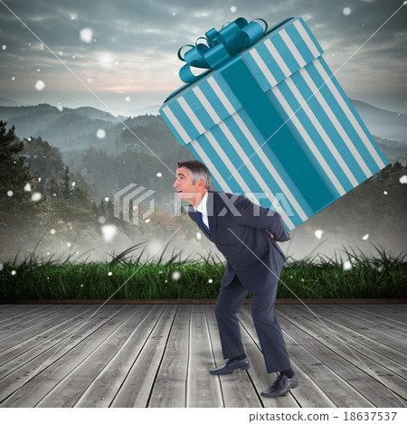 Composite image of stylish man with giant gift Composite image of stylish man with giant gift 18637537