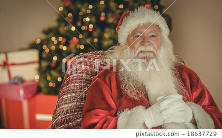 Smiling santa claus relaxing on the armchair 18637729
