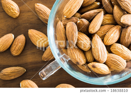 Almond in a transparent cup on a wooden table 18638810
