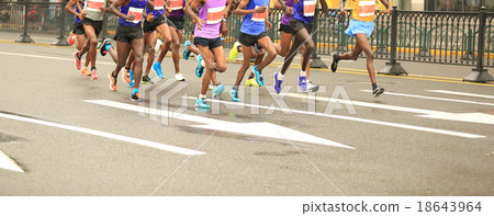 marathon runners running on city road 18643964