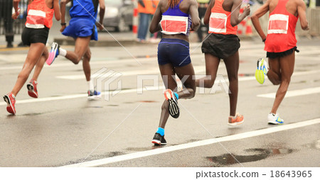 marathon runners running on city road 18643965