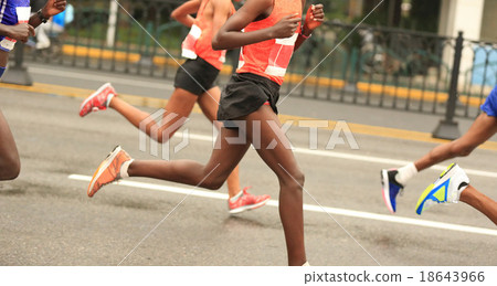 marathon runners running on city road 18643966