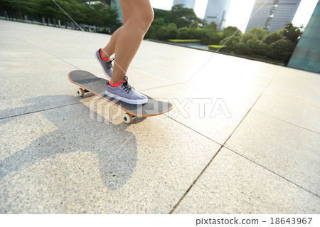 young woman skateboarder riding skateboard on city 18643967