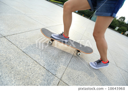 young woman skateboarder riding skateboard on city 18643968