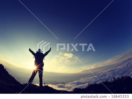 backpacker hiking on sunset mountain peak 18645353