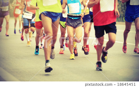 Many marathon runners running on city road Many marathon runners running on city road 18645451