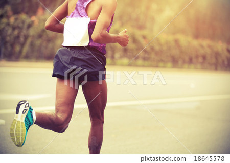 Stock Photo: Marathon runner running on city road