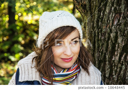 Young positive woman posing in autumn park, seasonal fashion Young positive woman posing in autumn park, seasonal fashion 18648445