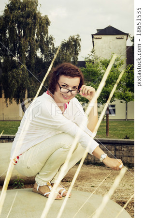 Smiling young woman with modern glasses posing on the stone 18651535