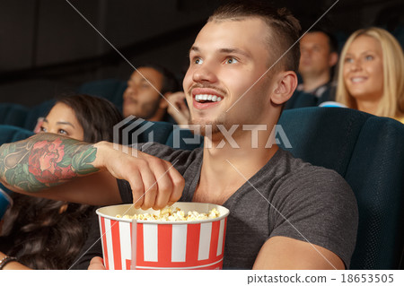 Young man laughing during a comedy film Young man laughing during a comedy film 18653505
