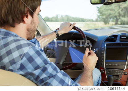 Young man using tablet while sitting in the car Young man using tablet while sitting in the car 18653544