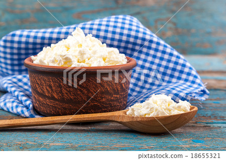 Fresh cottage cheese in a ceramic dish and spoon 18655321