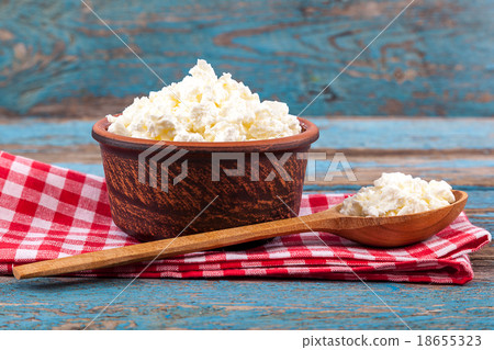 Fresh cottage cheese in a ceramic dish and spoon 18655323