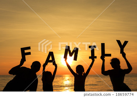 Happy family standing on the beach at the sunset time. Happy family standing on the beach at the sunset time. 18659774