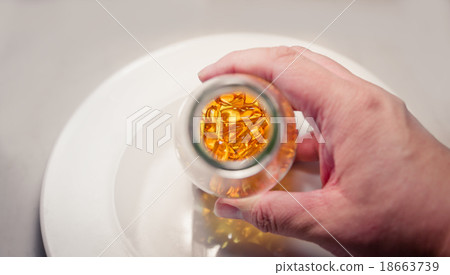 Man hand hold bottle to show fish oil pills  18663739