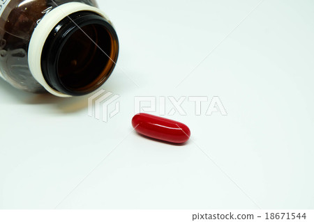 A red pill and a brown glass bottle A red pill and a brown glass bottle 18671544