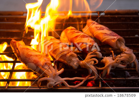 buttered fresh squid on flaming grill 18678509
