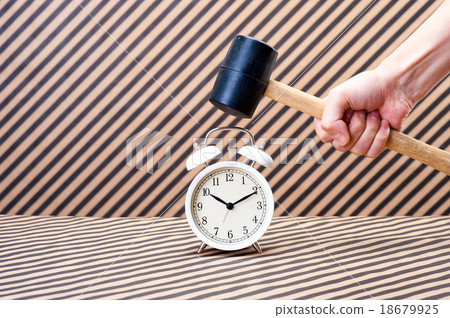 Hand that breaks the alarm clock with a hammer 18679925